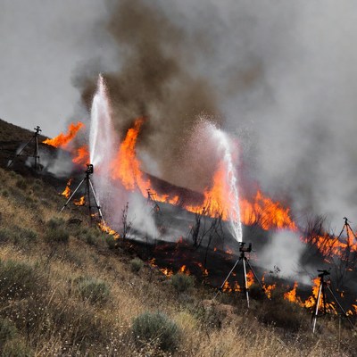 Wildfire Burning Hillside with Water Sprays