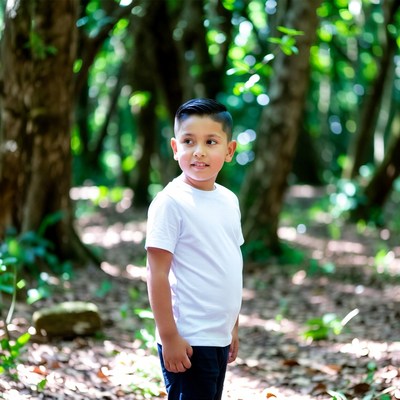 Young boy standing in lush forest