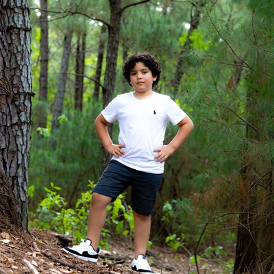Boy posing in pine forest