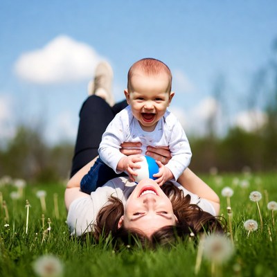 Mother and baby playing with ball on grass