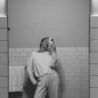 Woman taking selfie in bathroom mirror