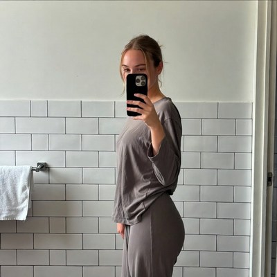 Woman in gray outfit taking mirror selfie