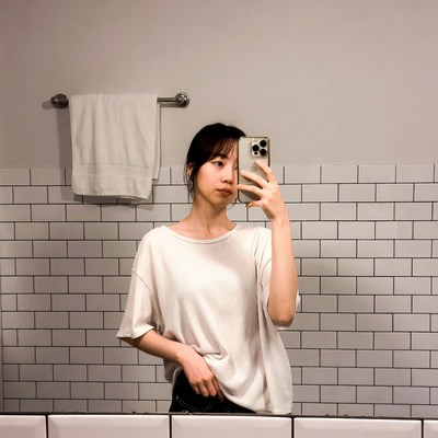 Asian woman taking selfie in bathroom