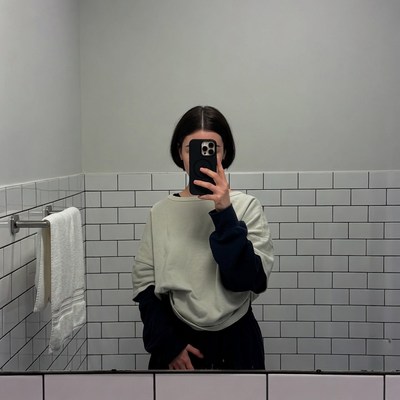 Woman taking selfie in bathroom mirror