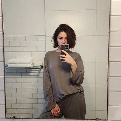 Woman taking selfie in bathroom mirror