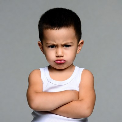 Asian toddler boy with arms crossed pouting