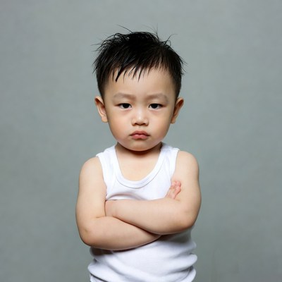 Asian toddler boy arms crossed pouting