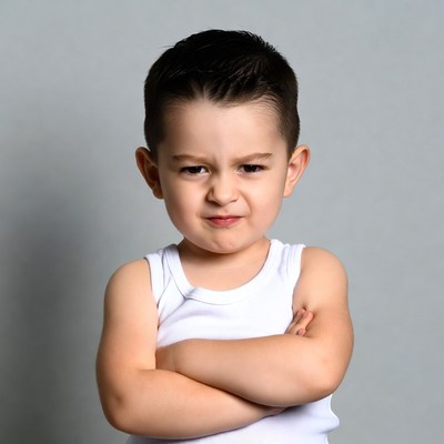 Angry toddler boy with arms crossed