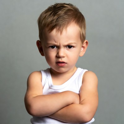 Boy with arms crossed angry face