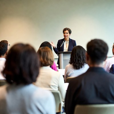 Woman speaking at podium to audience