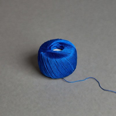 Blue thread spool on gray background