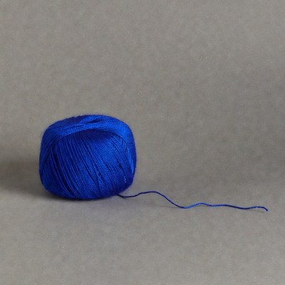 Blue yarn ball with trailing thread