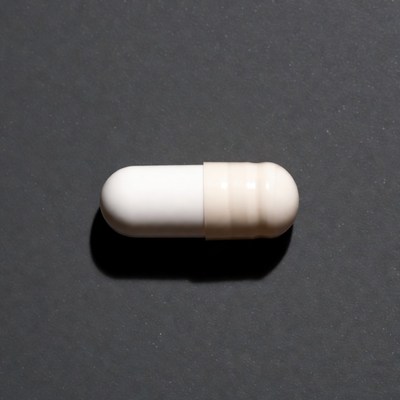 White capsule pill on black background