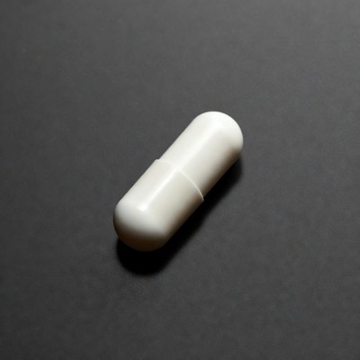 White capsule pill on dark background