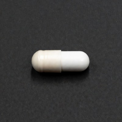White capsule pill on black background