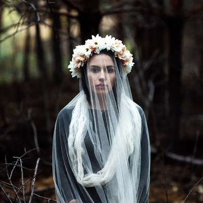 Woman with flower crown and veil in forest