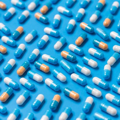 Colorful pills scattered on blue background