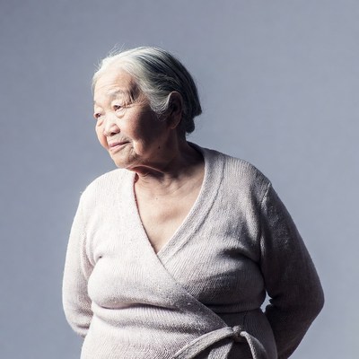 Elderly Asian woman in pink cardigan