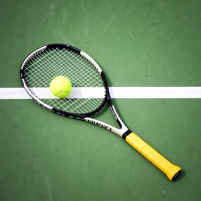 Tennis racket and ball on court