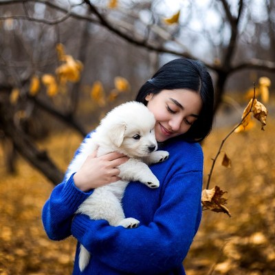 Asian woman holding white puppy