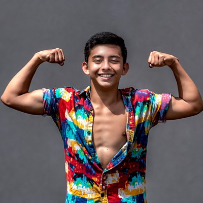 Young man flexing muscles in colorful shirt