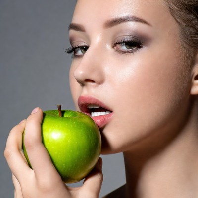 Woman biting green apple