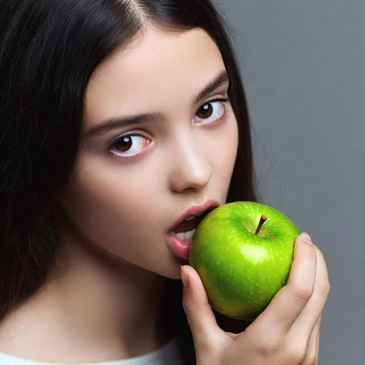 Girl biting green apple