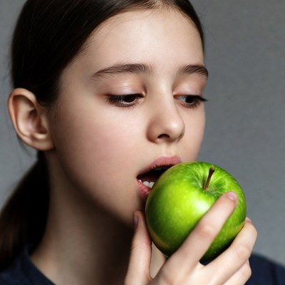 Girl biting green apple