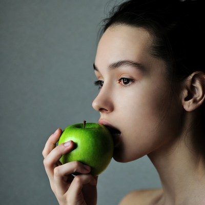 Woman biting green apple