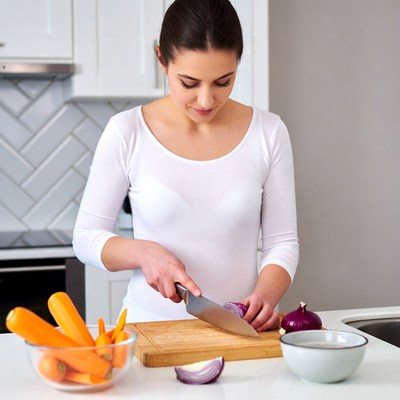 Woman chopping onions and carrots
