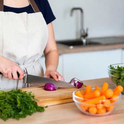 Woman chopping onion in kitchen