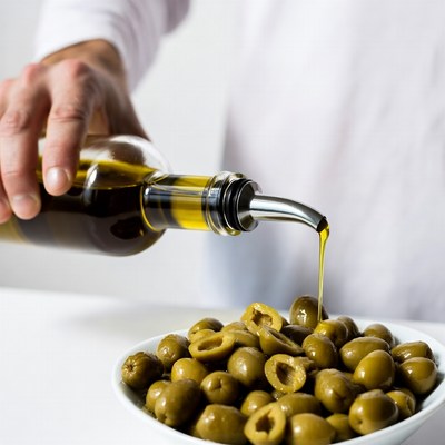 Man pouring oil on olives
