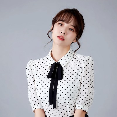 Asian woman in polka dot blouse
