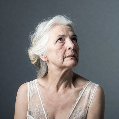 Elderly woman in lace dress looking up