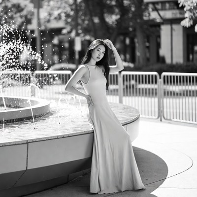 Asian woman in dress by fountain