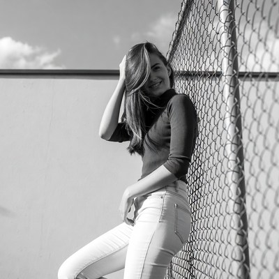Woman leaning on chain link fence