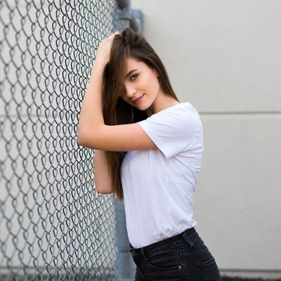 Woman leaning on chain link fence