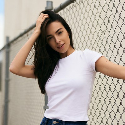 Woman posing by chain link fence