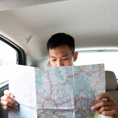 Asian man reading map in car