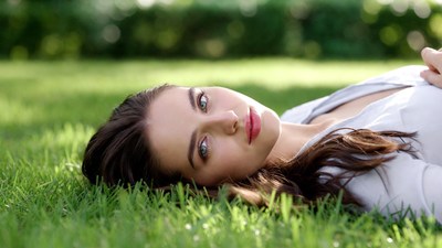 Woman lying on green grass