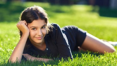 Girl lying on green grass