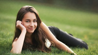 Young woman lying on green grass