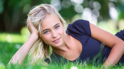 Blonde woman lying on grass