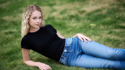 Blonde woman lying on grass