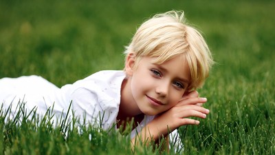 Blonde boy lying on grass
