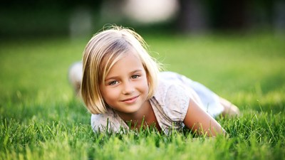Blonde girl lying on grass