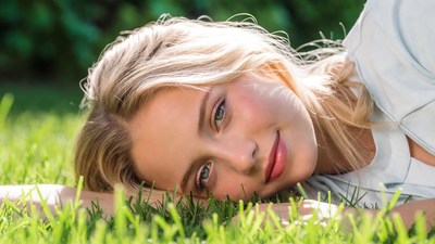 Blonde woman lying on grass