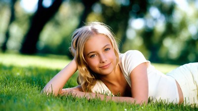 Blonde girl lying on grass