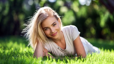 Blonde woman lying on grass