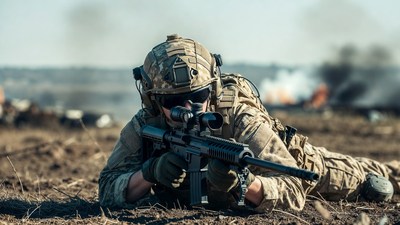 Soldier aiming rifle prone in combat